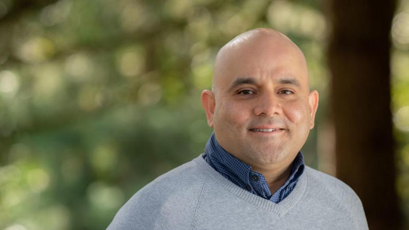 Utpal Passi headshot in front of trees at Oregon Zoo