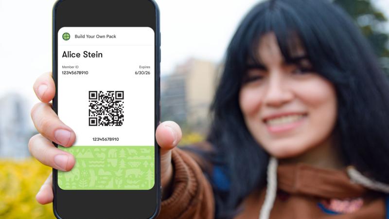 woman holding phone with membership card displayed