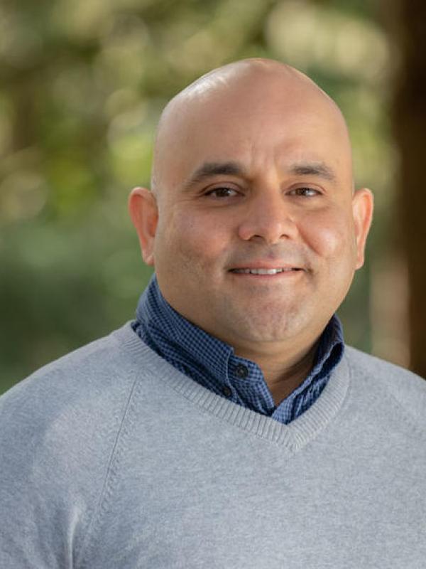 Utpal Passi headshot in front of trees at Oregon Zoo