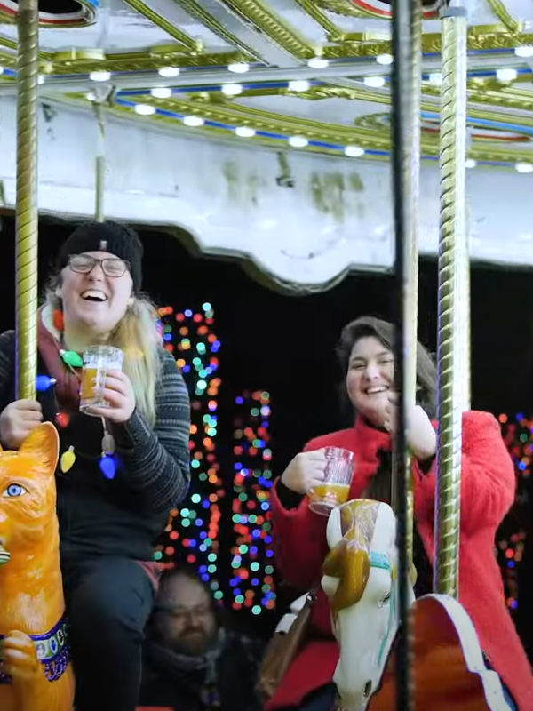 Two people ride the carousel. 