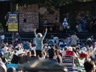A crowd listens to music on the concert lawn. 