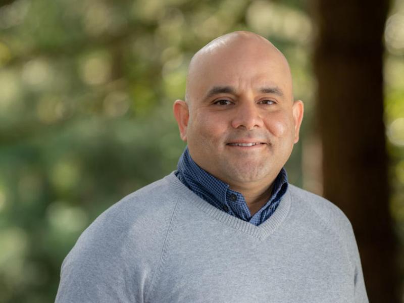 Utpal Passi headshot in front of trees at Oregon Zoo