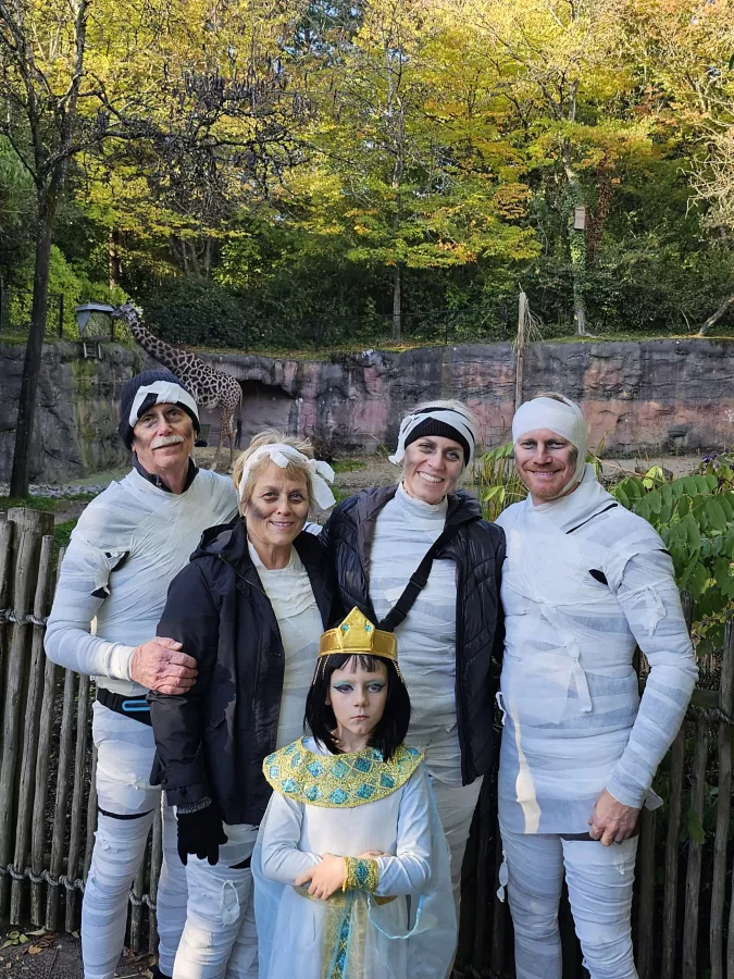 A child dressed as Cleopatra standing in front of 4 adults dressed as mummies
