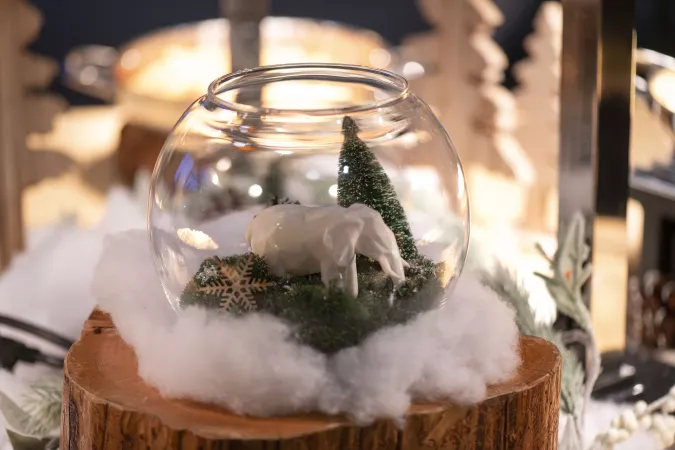 holiday table setting with elephant sculpture and pine tree in glass bowl