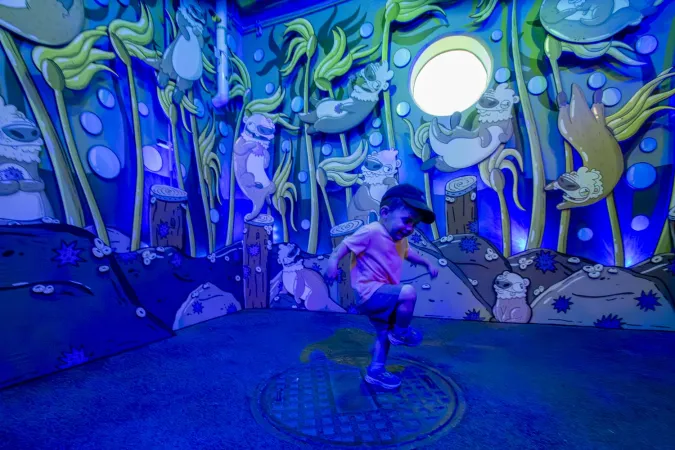 A young visitor plays at the Oregon Zoo’s new sea otter art installation, created by Mike Bennett.